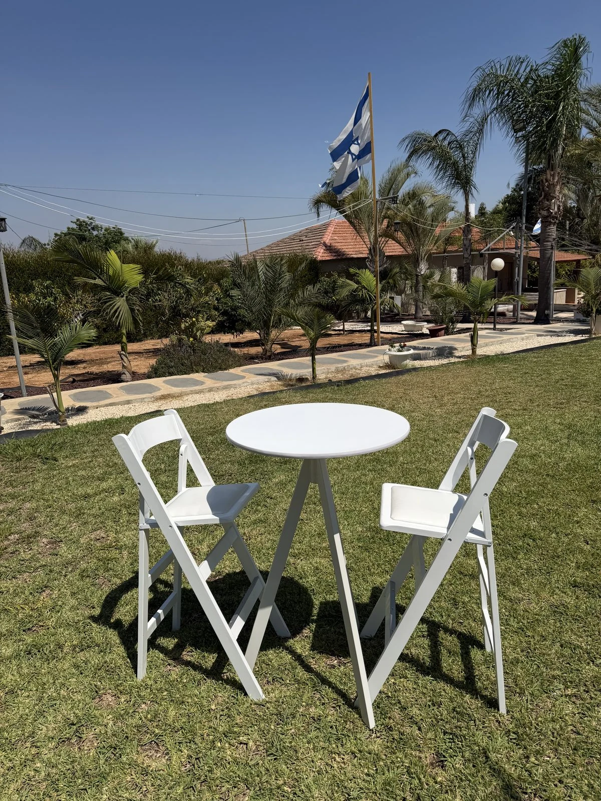שולחן בר עגול עם פלטה לבנה וכיסאות בר באירוע