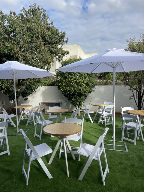 פינות ישיבה להשכרה לאירועים עם שולחנות עגולים, כיסאות ושמשיות לבנות