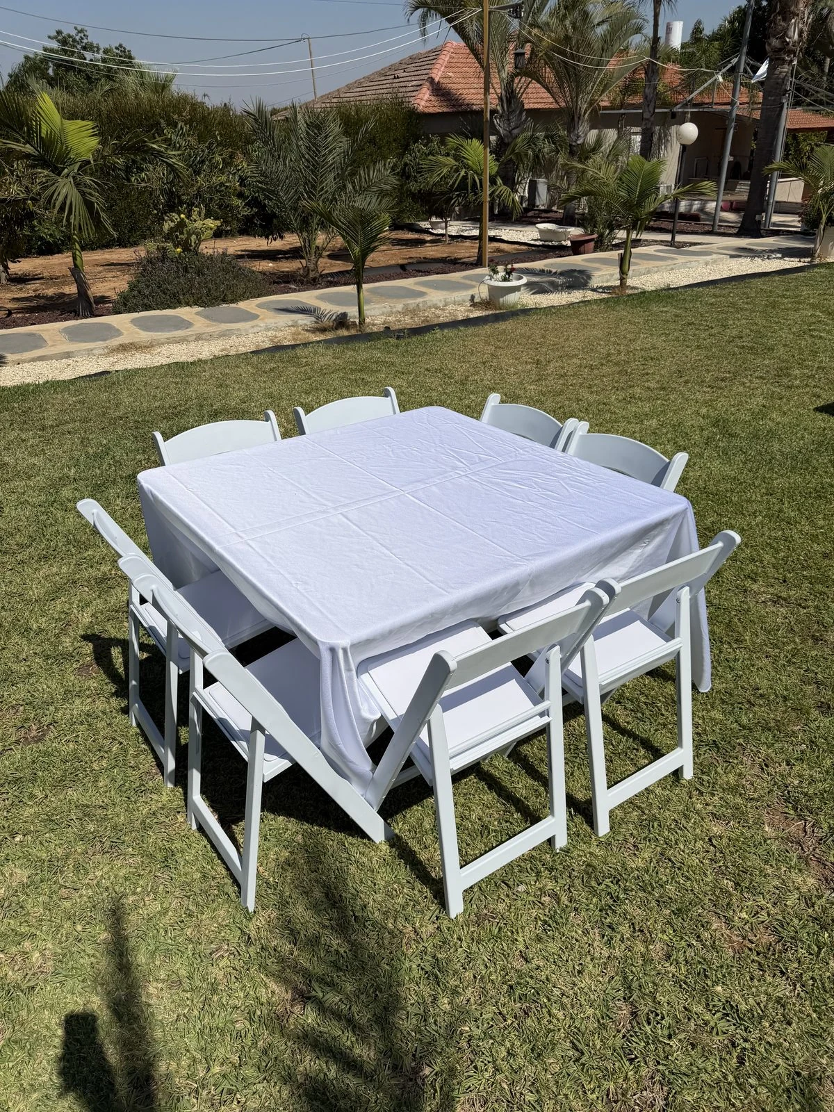שולחן מרובע 120 על 120 סנטימטר מסודר לשמונה אנשים באירוע